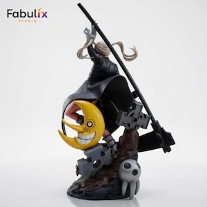 Side angle render of Maka Albarn from Soul Eater posed on a gothic display base surrounded by stone crosses, iconic moon decoration, and detailed collectible presentation.