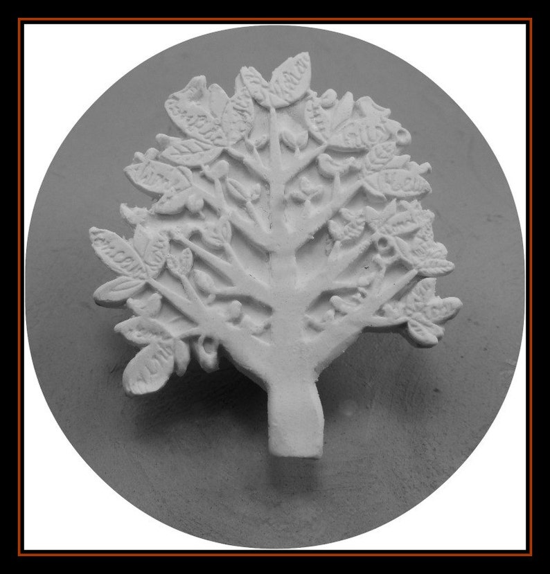 May include: A white ceramic tree sculpture with a detailed design of leaves and branches. The tree is mounted on a round, white base.
