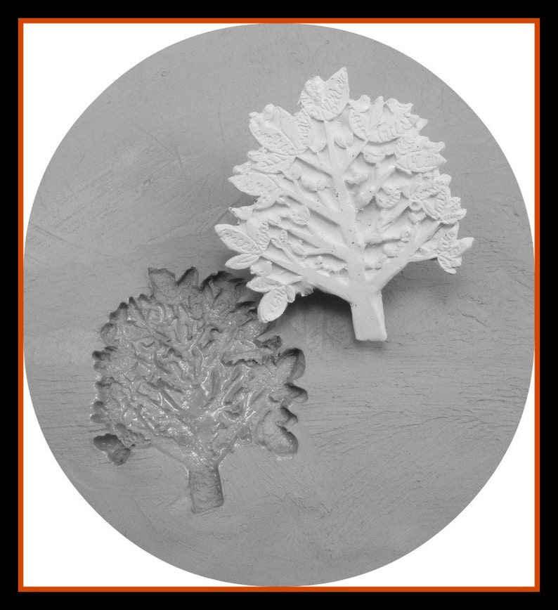 May include: A close-up of a grey silicone mould with two tree designs. The mould is circular and has a textured surface. One tree design is detailed with leaves and the other is more abstract.