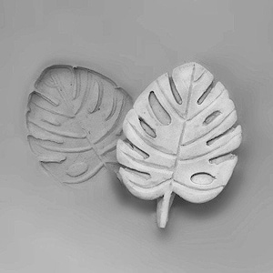 May include: Two grey concrete leaf-shaped decorative items. The leaves are in the shape of a monstera plant.