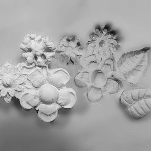 Peut inclure: Décor mural floral en plâtre blanc avec une variété de formes de fleurs et de feuilles. Le décor est fait d'un plâtre lisse et texturé et a une touche délicate et féminine.