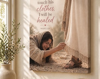 May include: A canvas print displays a biblical scene with the text "If I just touch his clothes, I will be healed." A woman reaches towards a figure's garment. The print is displayed on a wall above a wooden table with books and a vase.