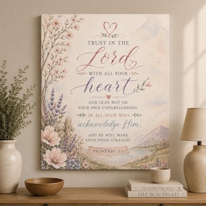 Puede incluir: Un lienzo rectangular para pared con el texto Trust in the Lord with all your heart and lean not on your own understanding; in all your ways acknowledge Him, and He will make your paths straight. Proverbs 3:5. El diseño incluye ilustraciones florales, un paisaje con montañas y un pequeño icono de corazón.