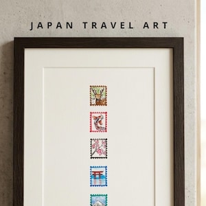 May include: A framed vertical print titled JAPAN TRAVEL ART featuring five postage stamp illustrations arranged in a column. The stamps depict a deer, a koi fish, cherry blossoms, a red torii gate, and Mount Fuji, with the text CELEBRATING JAPAN A COLLECTOR'S POSTAL JOURNEY below.