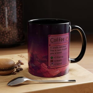 May include: A coffee mug with a black handle and a purple and red landscape design. The mug features the word "Coffee" and text that reads "It smells delicious. This is sure to give you a boost." The mug also has a list of stats.