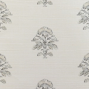 Puede incluir: Tela color crema con un estampado floral repetido en negro y beige. El diseño presenta motivos florales estilizados dispuestos en un diseño de cuadrícula, creando una estética simétrica y elegante. La tela tiene una apariencia sutilmente texturizada.