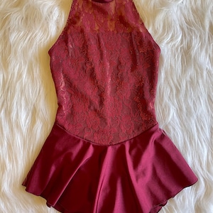 May include: A burgundy dance leotard with a lace bodice and a ruffled skirt.