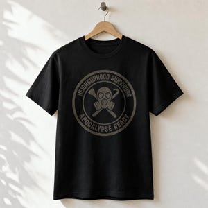Puede incluir: Una camiseta negra de manga corta con un gráfico circular en el centro. El diseño incluye una máscara de gas con herramientas cruzadas y el texto NEIGHBORHOOD SURVIVORS APOCALYPSE READY impreso en una fuente gris desgastada.