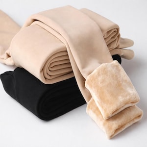 Peut inclure: Leggings beiges et noirs pliés. Les leggings beiges ont un intérieur doux et duveteux. Les leggings noirs sont pliés sous la paire beige. Les leggings sont faits d'une matière douce.