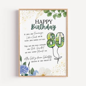 Könnte beinhalten: Ein gerahmter Geburtstagskunstdruck mit dem Text Happy Birthday und deutschen Geburtstagswünschen. Das Design zeigt grüne Aquarellblätter, goldene Sprenkel, blaue und weiße Blumen sowie die Zahl 80, gefüllt mit einem 100-Euro-Geldschein-Muster.