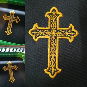May include: Embroidered gold cross with ornate detailing on a black background. The cross features a decorative border and intricate patterns within its arms and stem. The image shows the cross in multiple views, highlighting the embroidery work.