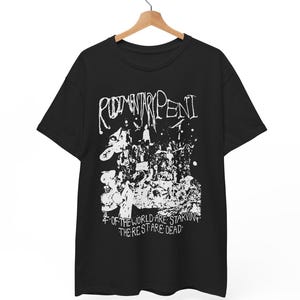 May include: Black t-shirt with a white graphic design. The design includes the band name "Rudimentary Peni" in a stylized font, along with a detailed illustration and the text "Of the world are starving, the rest are dead."