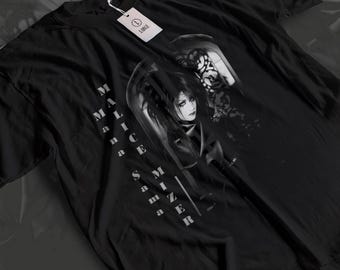 May include: Black t-shirt featuring a grayscale graphic of a person with long hair and gothic-style imagery. The text "MALICE MIZER" is printed vertically on the left side. A white tag with the word "LARGE" is attached to the collar.