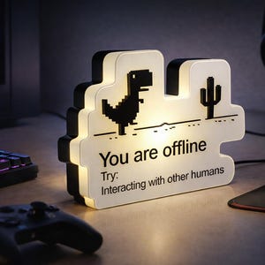 May include: A white and black pixelated light shaped like a puzzle piece, with a dinosaur, cactus, and the text "You are offline". The lamp is on a desk with a keyboard, controller, and mouse.