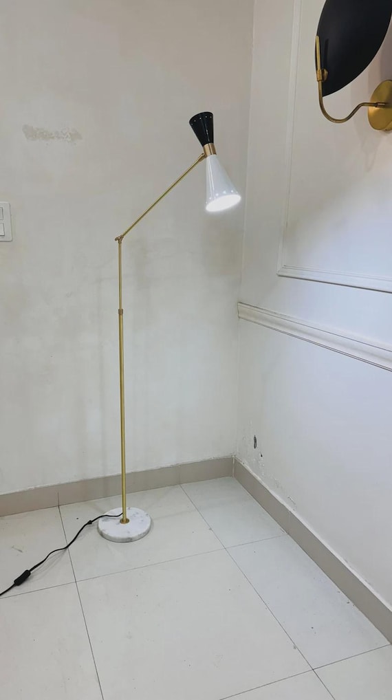 A handmade adjustable brass floor lamp in the Stilnovo tradition — the kind of piece that anchors a room and makes guests ask 'where did you find that?'