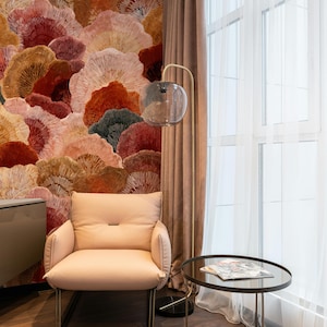 May include: A contemporary interior scene with a pale pink armchair, a circular side table, and a floor lamp with a globe-shaped shade. The wallpaper features a floral design in red, orange, and brown tones.