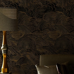 May include: A dark, patterned wallpaper with a repeating design of swirling lines in gold against a black background. A gold lamp with a gray shade and a bed with pillows are in the foreground. The wallpaper creates a dramatic, textured effect.