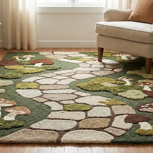 Puede incluir: Una alfombra verde con un diseño caprichoso que presenta un camino de piedra que serpentea a través de una escena de bosque. Grandes y detalladas setas y parches de musgo están esparcidos por la alfombra, creando una estética lúdica inspirada en la naturaleza.