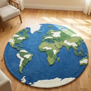 May include: A circular rug featuring a world map design, with green and white continents set against a blue ocean. The rug is on a wooden floor, with a sofa and chairs nearby. The rug's diameter is approximately 200 cm.