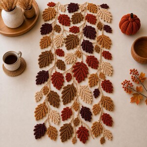 May include: A rectangular table runner featuring a crocheted vine pattern with numerous leaves in shades of cream, tan, brown, rust, and deep burgundy. The intricate design consists of interconnected chains and textured leaf motifs arranged in a vertical, flowing composition.