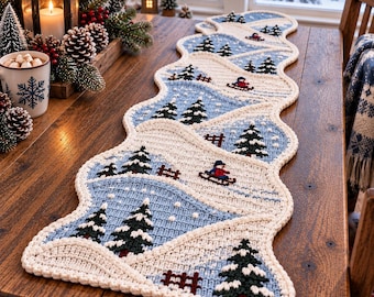 May include: A long, scalloped-edge table runner featuring a repeating winter landscape pattern. The knit design displays snow-covered hills, dark green pine trees, brown fences, and small figures sledding in shades of blue, white, and cream.
