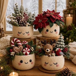 May include: Four cream-colored crocheted pots with embroidered smiling faces, each filled with festive holiday arrangements including red poinsettias, a brown reindeer, a gingerbread heart, candy canes, pinecones, and evergreen sprigs.