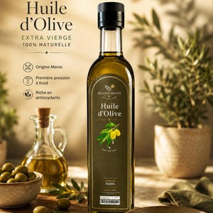 May include: A tall, rectangular olive oil bottle with a black cap and a dark green label. The label features the text "Huile d'Olive" and a sprig of olives. The bottle is 500ml. Other bottles and bowls of olives are in the background.