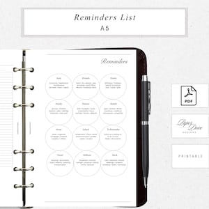 May include: A5 printable planner insert with a "Reminders List" header. The page features a dark brown leather binder with a black pen and circular categories for tasks like "Auto", "Errands", "Events", and "Family".