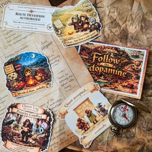 May include: A collection of fantasy-themed stickers featuring characters and text including "Okay... but first a side quest," "We ride at dawn... probably," "Quest Log," and "Quest accepted... eventually," alongside a "Follow the dopamine" card and a metal compass.