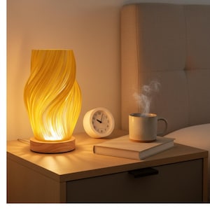 May include: A yellow, swirled-design table lamp with a wooden base sits on a nightstand. A white analog clock and a mug of steaming coffee are also on the nightstand. The lamp is lit, casting a warm glow.