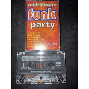 Puede incluir: Una taza de cerámica blanca con un asa negra y el texto "But First, Coffee" en un estilo manuscrito. La taza está sobre una superficie blanca. La taza mide 10 cm de alto.