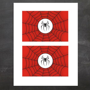 Puede incluir: Dos impresiones rectangulares con un diseño de telaraña roja con un círculo blanco en el centro. Dentro del círculo hay un gráfico de araña negra. El fondo es rojo degradado.