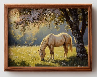 May include: A framed print of a horse grazing in a field. The horse is a light tan color with a white mane and tail. The field is filled with wildflowers and is under a tree with white blossoms. The frame is a dark brown color.