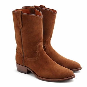 May include: A pair of brown suede cowboy boots. The boots have a classic Western design with a pointed toe, a mid-height shaft, and a stacked heel. The boots are made of a soft, textured suede material and feature a pull-on design.