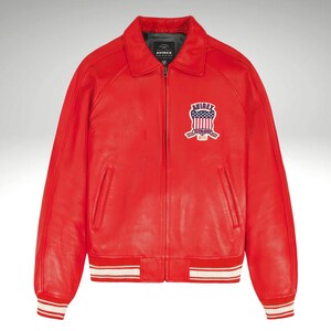 K&ouml;nnte beinhalten: Leuchtend rote Lederjacke im klassischen Bomber-Stil. Mit Kragen, Frontrei&szlig;verschluss und Brustaufn&auml;her mit amerikanischem Flaggen-Design. Die &Auml;rmel und der Saum sind mit wei&szlig;-roten Streifen versehen.