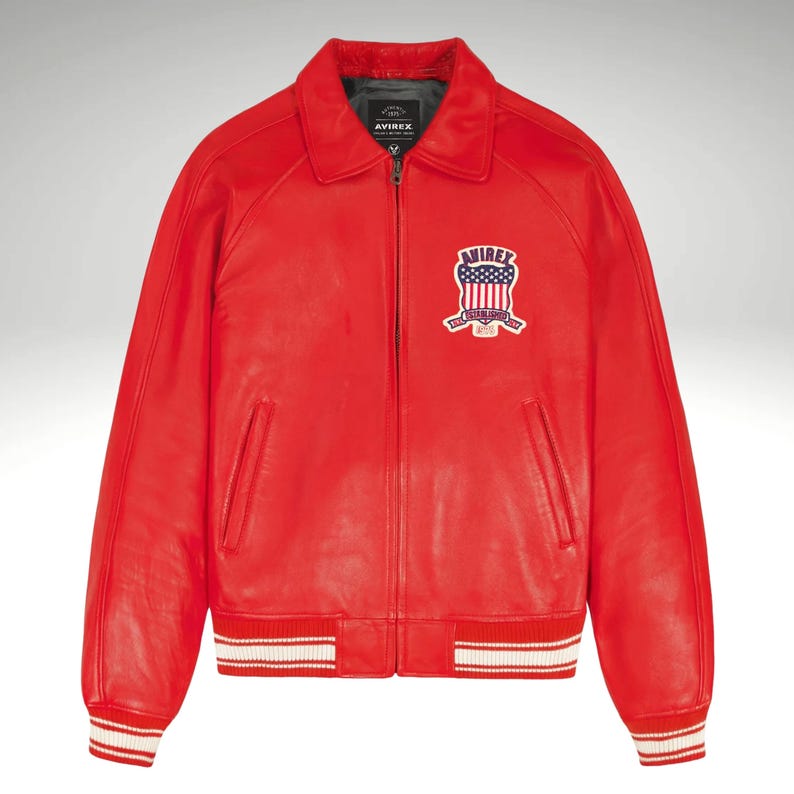 K&ouml;nnte beinhalten: Leuchtend rote Lederjacke im klassischen Bomber-Stil. Mit Kragen, Frontrei&szlig;verschluss und Brustaufn&auml;her mit amerikanischem Flaggen-Design. Die &Auml;rmel und der Saum sind mit wei&szlig;-roten Streifen versehen.
