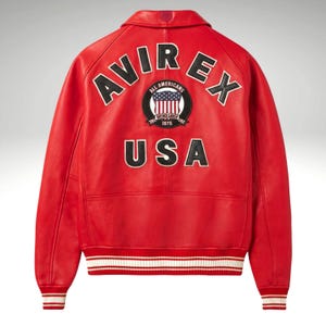 K&ouml;nnte beinhalten: Rote Lederjacke mit dem Wort "AVIREX" in wei&szlig;en Buchstaben &uuml;ber den Schultern. Ein kreisf&ouml;rmiger Aufn&auml;her mit den Worten "ALL AMERICANS" und "USA" ist ebenfalls sichtbar. Die Jacke hat wei&szlig;-rot gestreifte B&uuml;ndchen.