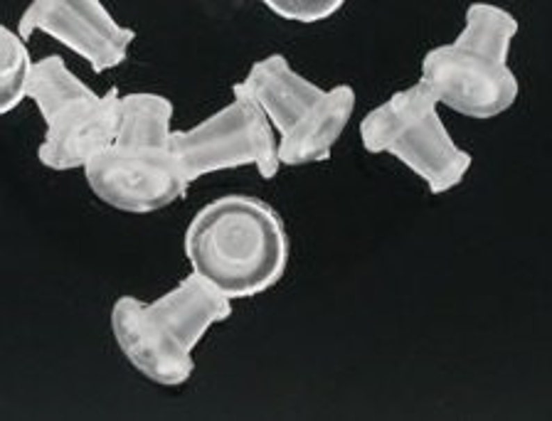 May include: A group of clear plastic earring backs. The backs are designed to fit over the post of an earring.