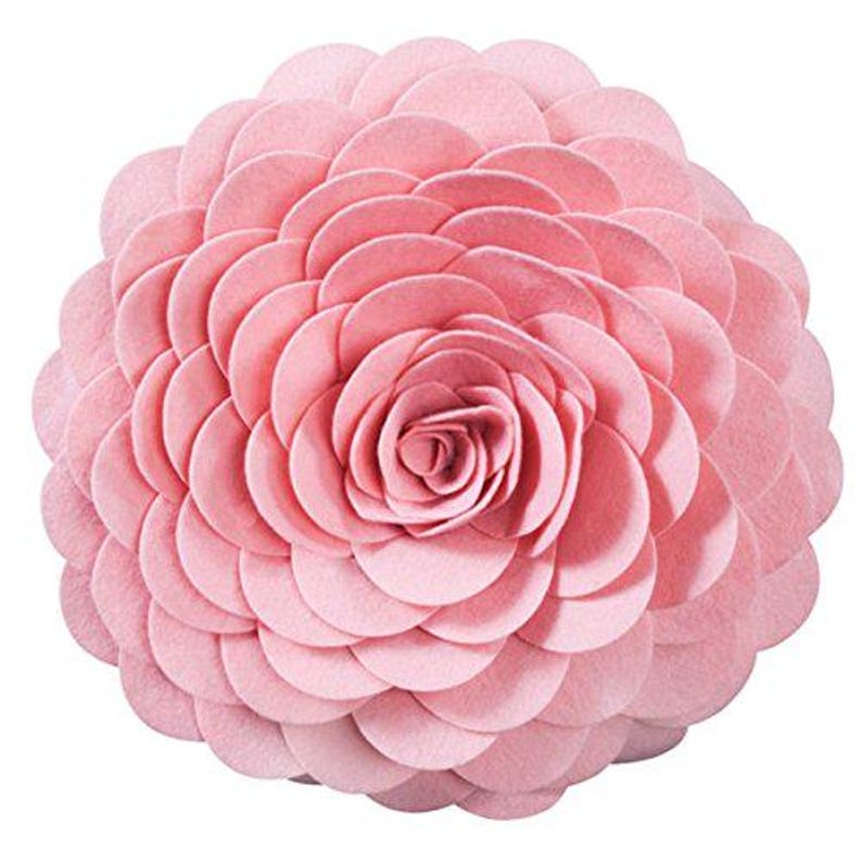 K&ouml;nnte beinhalten: Ein rundes Kissen aus rosa Filz in Form einer Blume mit einer gro&szlig;en, mehrschichtigen Rose in der Mitte. Das Kissen ist rund und hat eine weiche, pl&uuml;schige Textur.