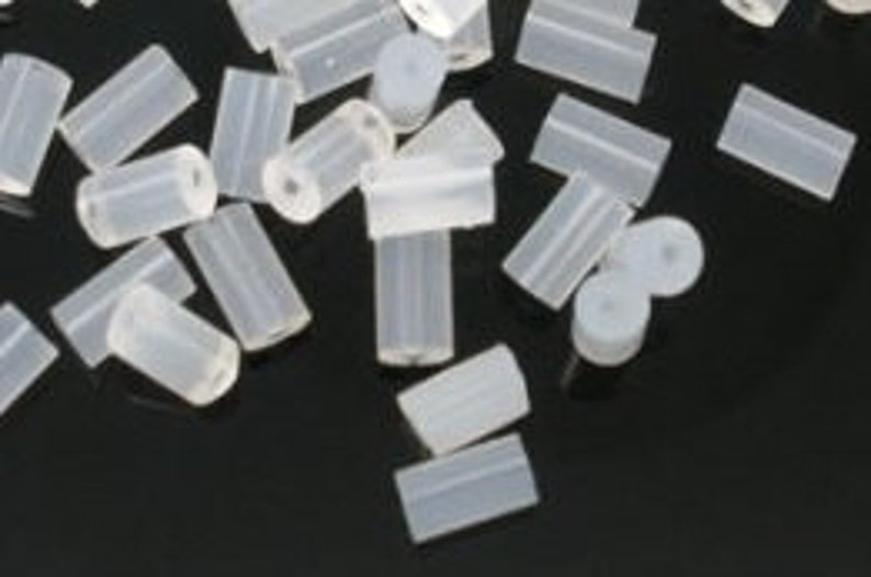 May include: A group of small, white, silicone, cylindrical tubes. The tubes are about 1/2 inch in diameter and 1 inch long.