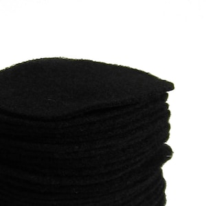 May include: A stack of black felt circles, likely for crafting or other projects.