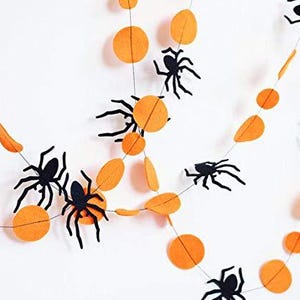 K&ouml;nnte beinhalten: Orange-schwarze Halloween-Girlande mit Filz-Kreisen und Spinnen.