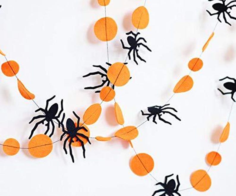 K&ouml;nnte beinhalten: Orange-schwarze Halloween-Girlande mit Filz-Kreisen und Spinnen.
