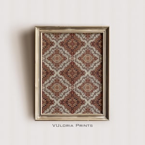 May include: A framed print featuring a repeating pattern of ornate, diamond-shaped designs in shades of red, brown, and beige. The print is set within a gold-colored frame. The text "VULORIA PRINTS" is printed at the bottom.