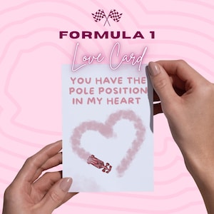 Puede incluir: Una tarjeta de amor con temática de Fórmula 1 sostenida por manos. La tarjeta presenta el texto "YOU HAVE THE POLE POSITION IN MY HEART" con un diseño en forma de corazón y una ilustración de un coche de carreras. El fondo es de color rosa claro.