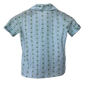 May include: A short-sleeved shirt with a collared neckline. The shirt features vertical stripes in light blue and white, with a repeating pattern of small green floral designs. The shirt is made of a lightweight fabric.