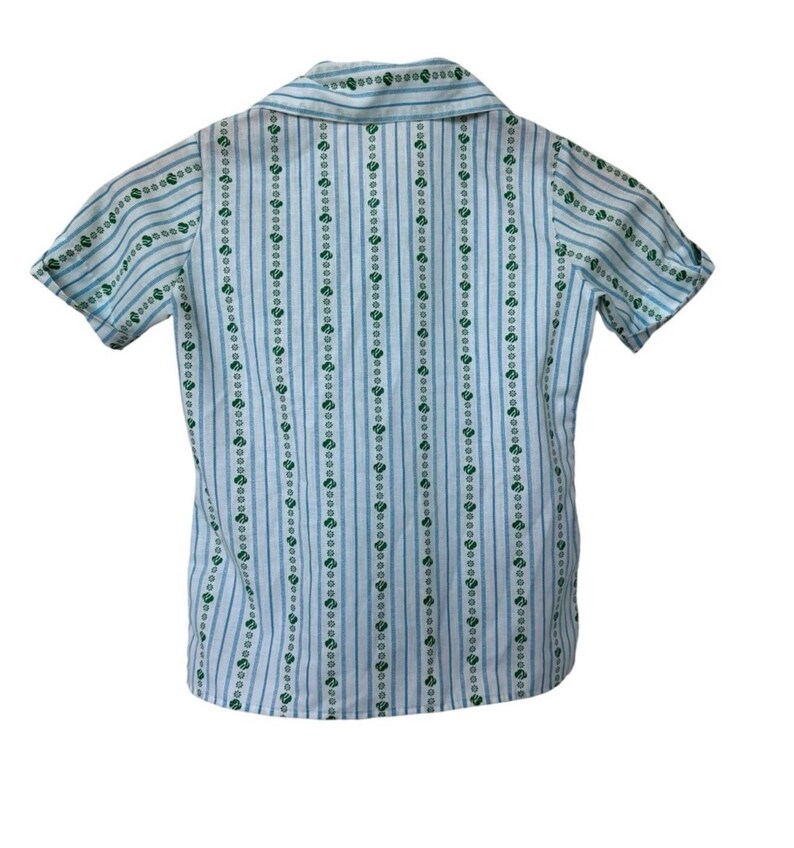 May include: A short-sleeved shirt with a collared neckline. The shirt features vertical stripes in light blue and white, with a repeating pattern of small green floral designs. The shirt is made of a lightweight fabric.