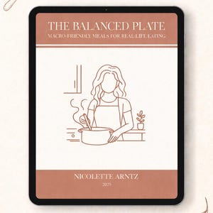 以下が含まれることがあります： デジタルタブレットには、「The Balanced Plate」というタイトルの料理本の表紙が表示され、「Macro-Friendly Meals for Real Life Eating」という副題が付いています。表紙には、料理をしている人の線画が描かれています。著者の名前と2025年も表示されています。