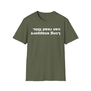 May include: An olive green t-shirt featuring the white text "Long snappers can read this." The text is in a sans-serif font and is centered. The shirt has a crew neck and short sleeves.