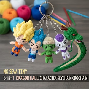 May include: A crocheted keychain with five Dragon Ball characters, including Goku and Vegeta. The characters are in various colours, attached to a silver chain and keyring. The text "NO SEW TINY" and "5-IN-1 DRAGON BALL CHARACTER KEYCHAIN CROCHAIN" are visible.